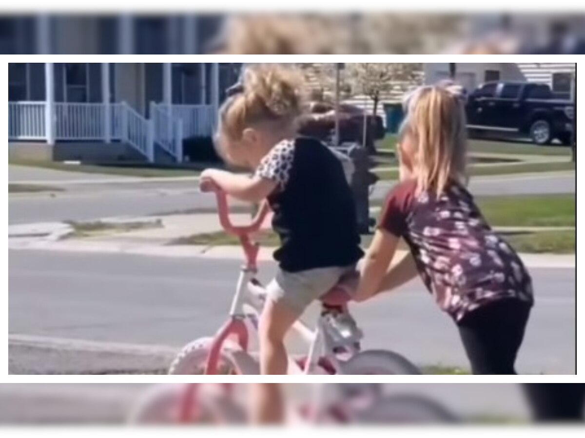 Heart-warming video of little girl helping baby sister to get on her  bicycle wins over