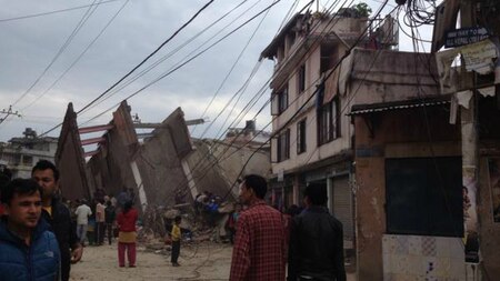 Bystanders look at the rubble of a building in Nepal.