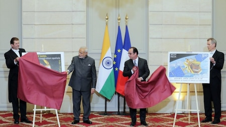 Indian Prime Minister Narendra Modi (L) and French President Francois Hollande unveil the designs for a French (L) and Indian postage stamp celebrating 50 years space cooperation.