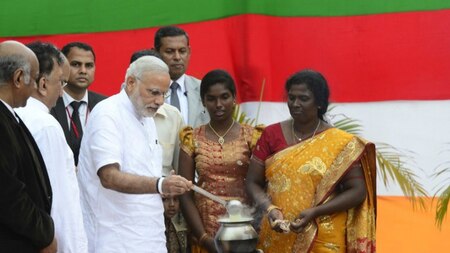 Indian Prime Minister Narendra Modi (centre L) takes part in a milk boiling ceremony as he handed over Indian-funded houses to Tamils displaced or made destitute by fighting in Jaffna, some 400 kilometres (250 miles) north of Colombo on March 14, 2015.