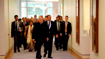 India's Prime Minister Narendra Modi (centre L) walks with Australia's Prime Minister Tony Abbott (centre R).