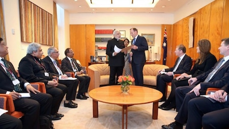India's Prime Minister Narendra Modi (centre L) gives an historial document from the 19th century to Australia's Prime Minister Tony Abbott (centre R)