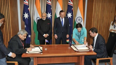 Indian Prime Minister Narendra Modi (centre L) and Australian Prime Minister Tony Abbott (centre R) watch as a memorandum of understanding between the Narcotics Control Bureau's is signed