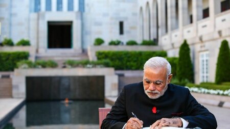 Indian Prime Minister Narendra Modi signs the visitors book at the Australian War Memorial.