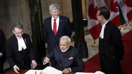 India's Prime Minister Narendra Modi signs a visitors book in Parliament Hill