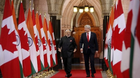 India's Prime Minister Narendra Modi (L), walks the Hall of Honour on Parliament Hill alongside Canada's Prime Minister Stephen Harper