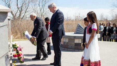 Canadian Prime Minister Stephen Harper (C) leaves a wreath with Indian Prime Minister Narendra Modi (L)