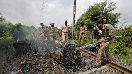 Policemen remove cables from a railway track