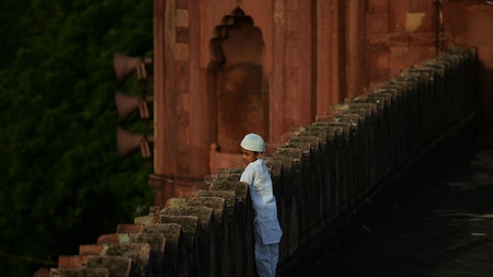 A Muslim child looks at the devotees offering prayers in New Delhi