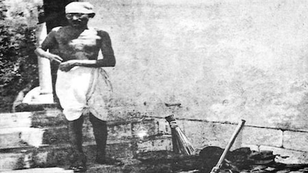 Mahatma Gandhi cleaning with a broom