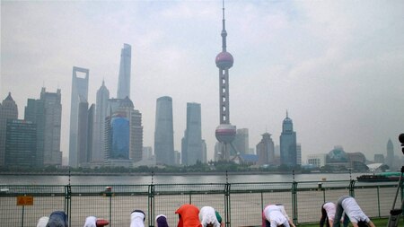 Chinese Yoga enthusiasts practicing at river front Bund in Shanghai