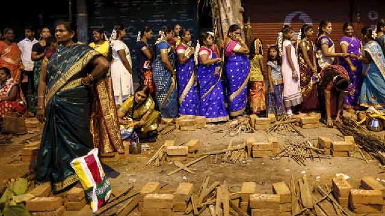 Devotees stand in a queue to collect utensils and ingredients