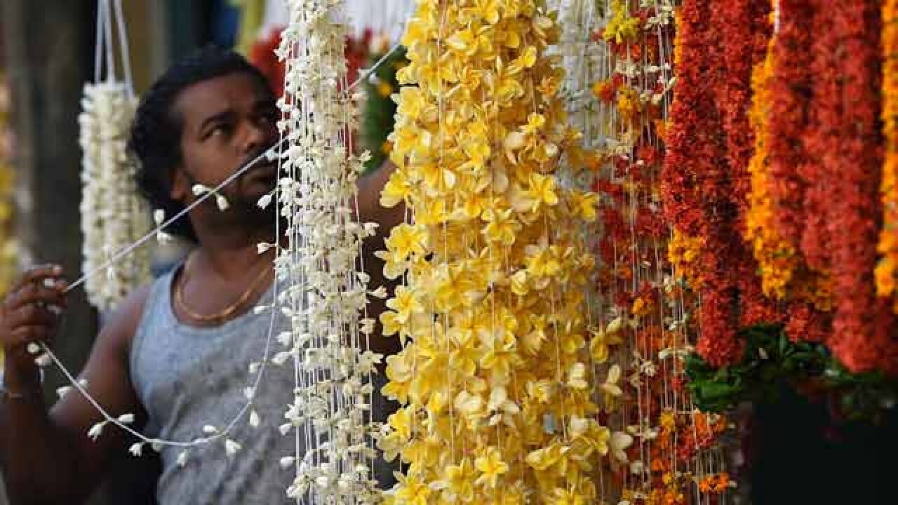 Vendor prepares flower garlands