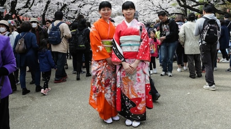 Women pose under the cherry blossoms