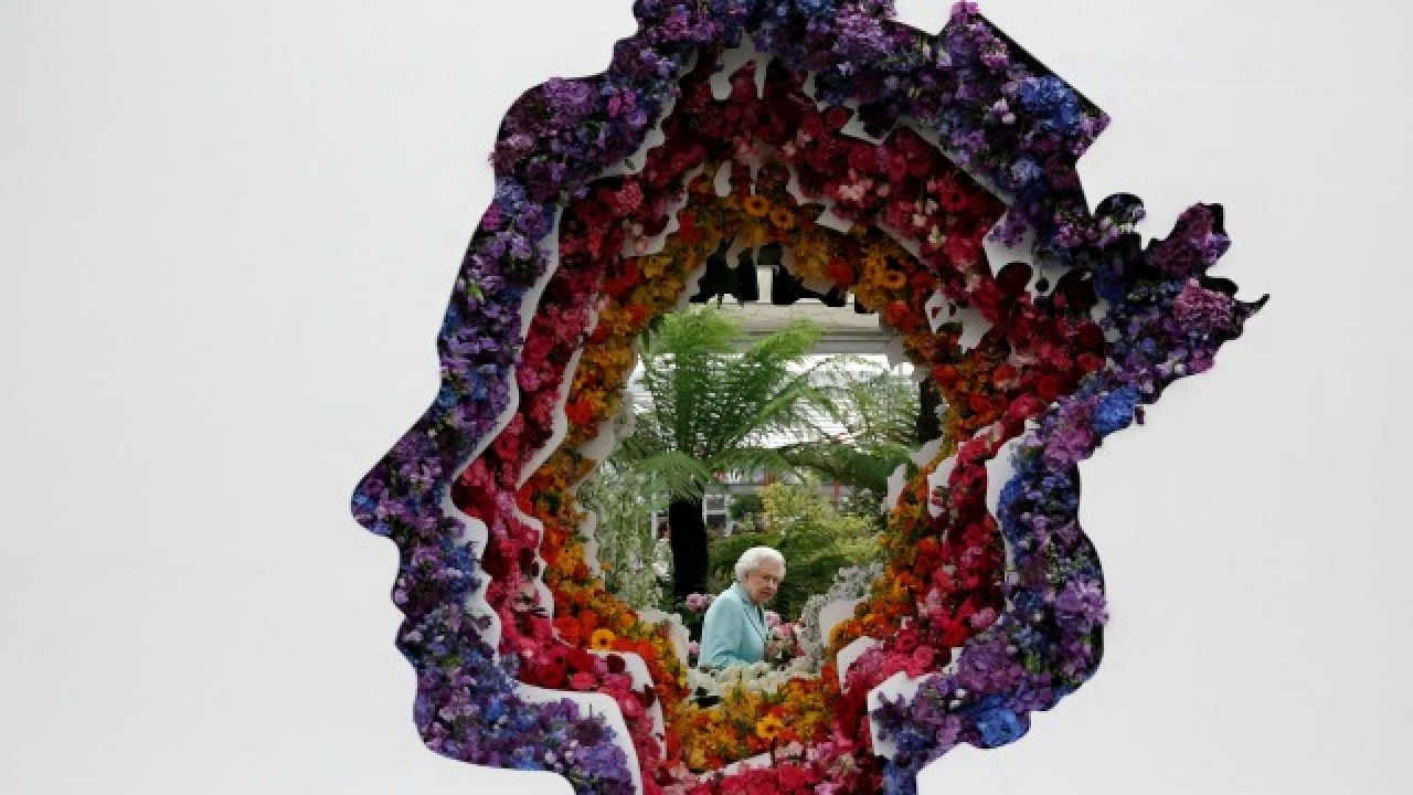 Queen Elizabeth II with a flower installation of the Queen