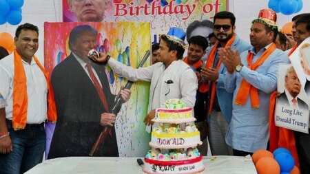 Vishnu Gupta giving cake to a photo of Donald Trump