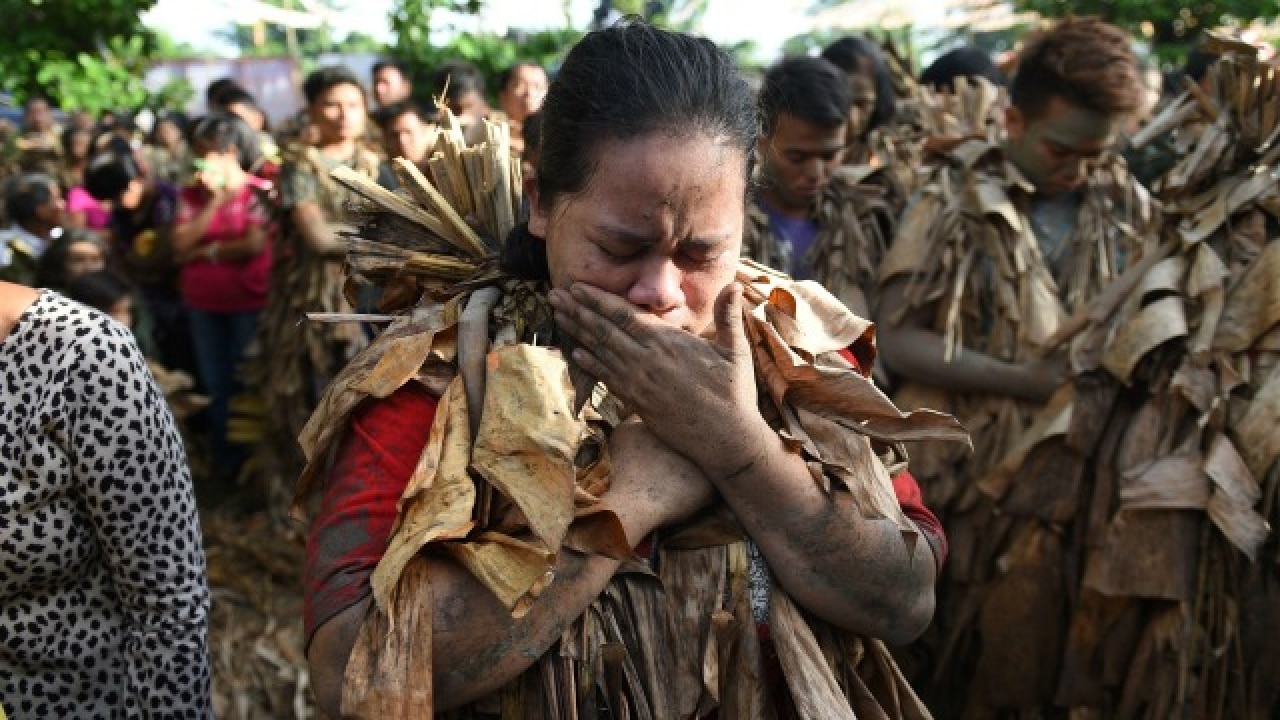 Devotee covers her face with mud