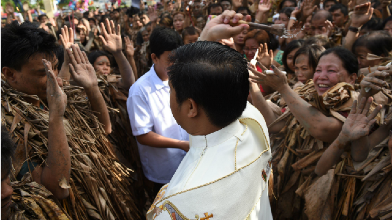 Catholic priest blessing devotees
