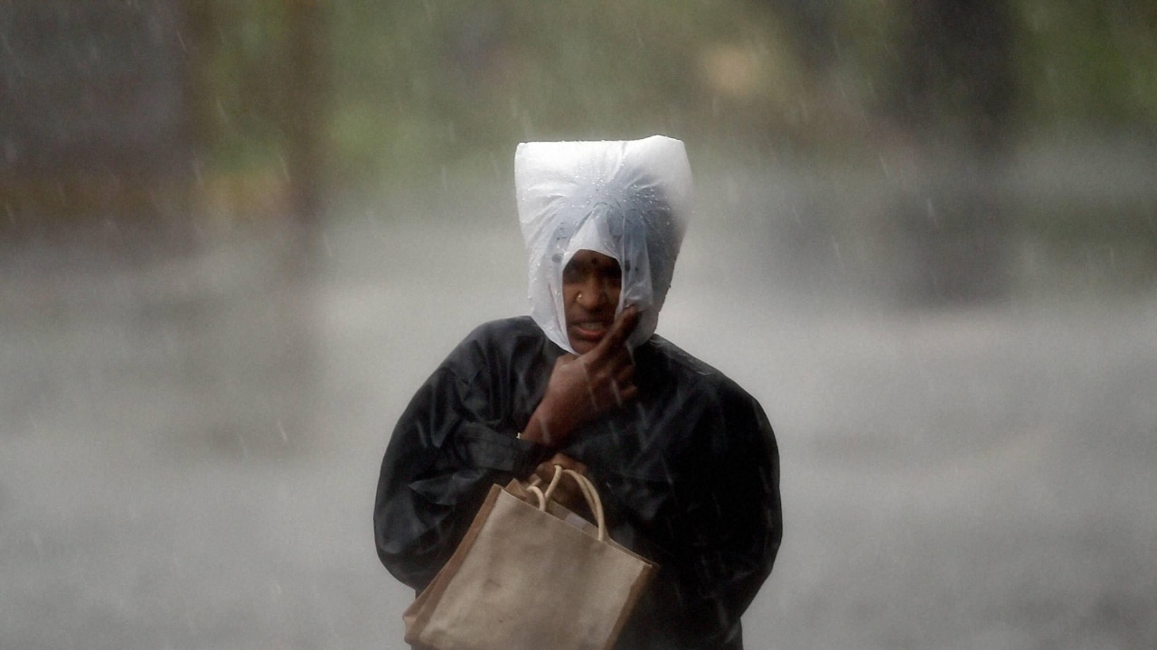 A person walks on road during heavy rainfall