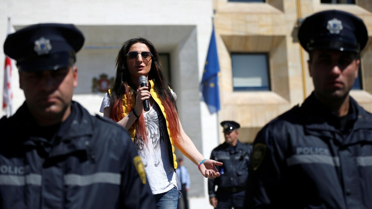 A LGBT activist speaks behind a police line in rally