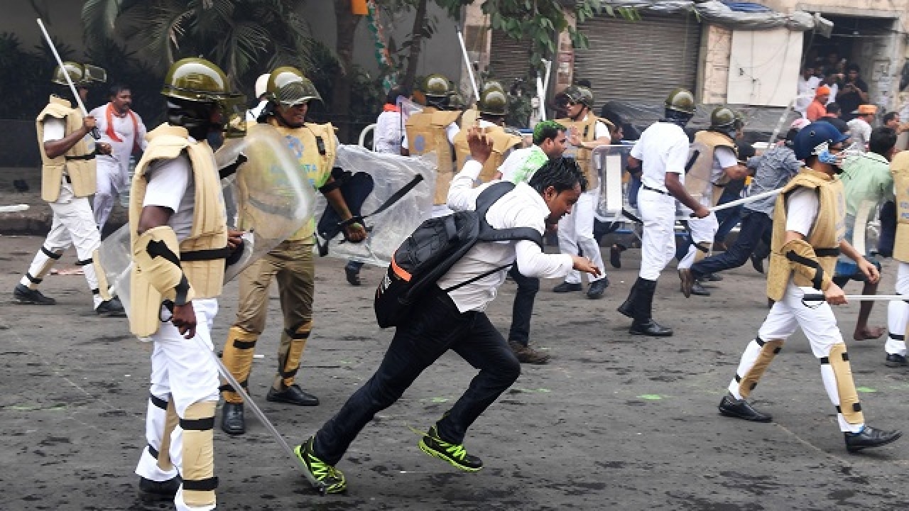 Activists run past police