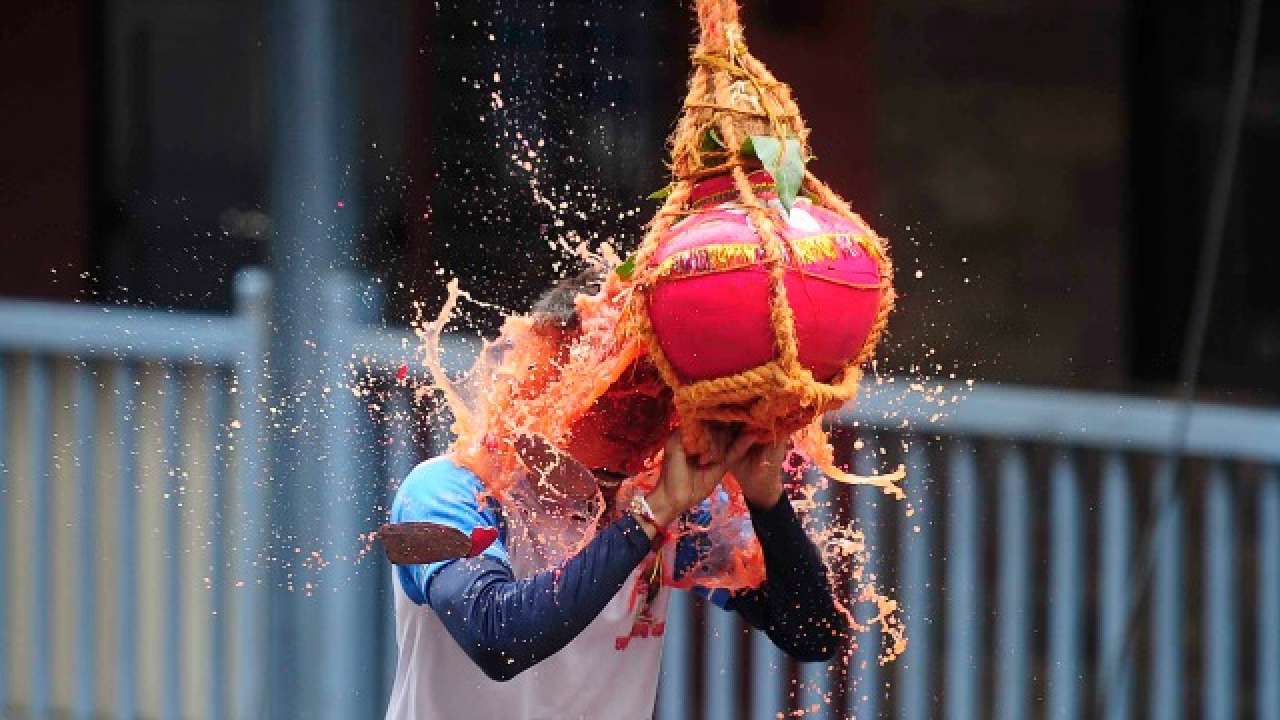 A boy breaks a Dahi Handi during celebration of Janmashtami festival in Mumbai