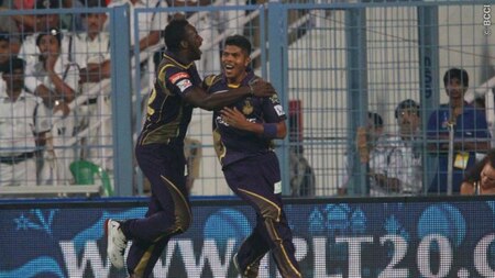 Umesh Yadav (L) celebrates with Andre Russell (L) after a successful catch of Aaron Finch