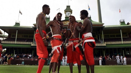Maasai Warriors from Kenya discuss tactics before commencing their cricket match