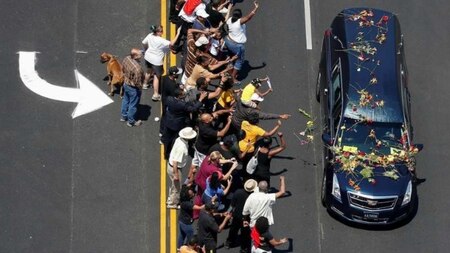 Well-wishers throwing flowers at a hearse