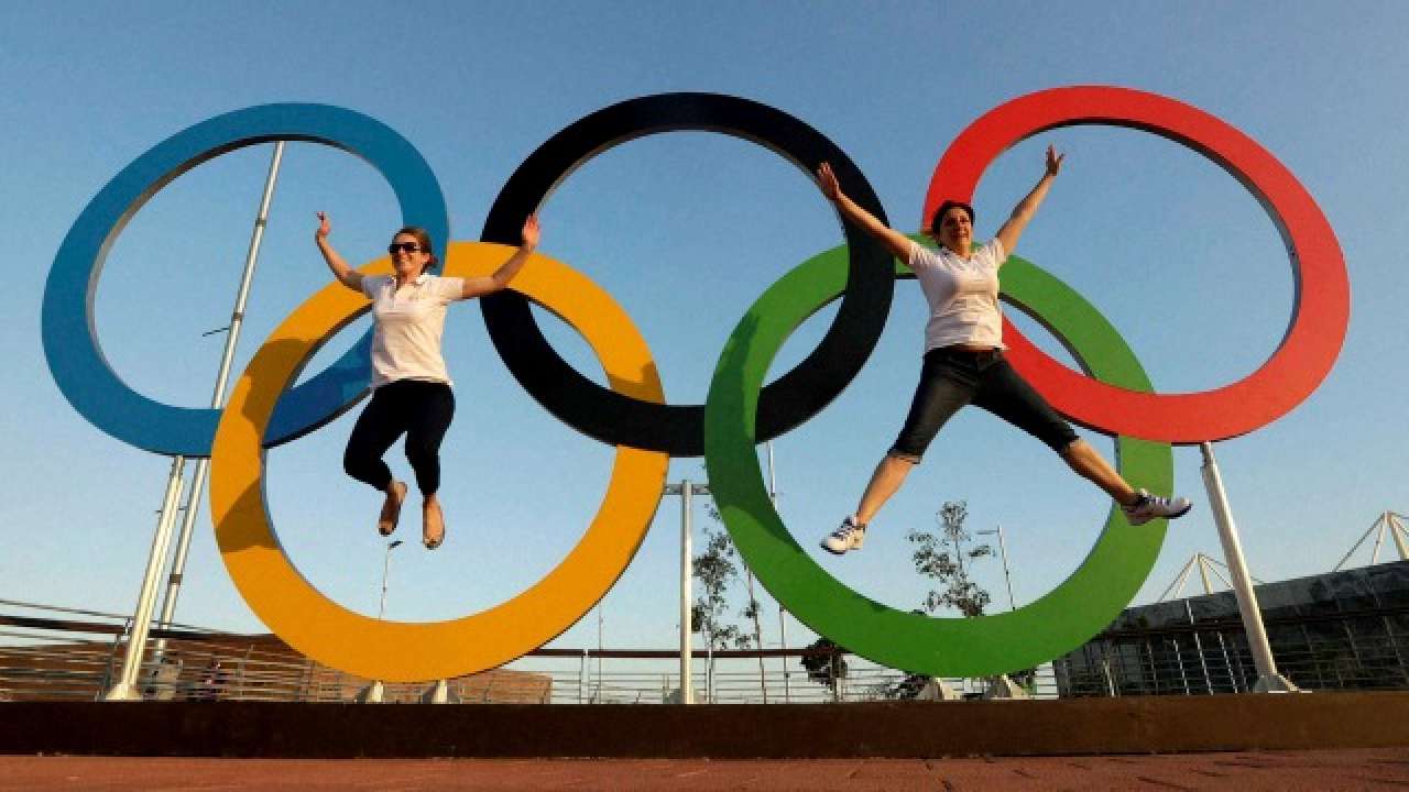 Visitors pose with the Olympic rings