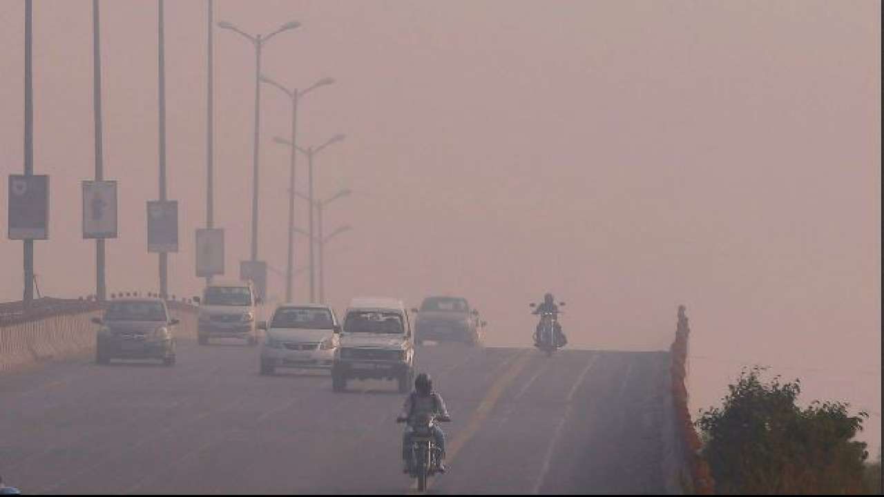 Traffic drives through smog