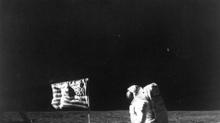 Edwin 'Buzz' Aldrin stands next to the US flag