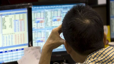 An investor reacts as he monitors share prices