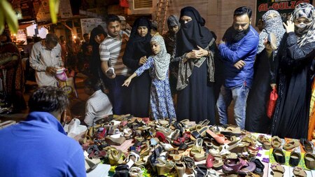 Men and women shop ahead of Eid al-Fitr during near Jama Masjid.