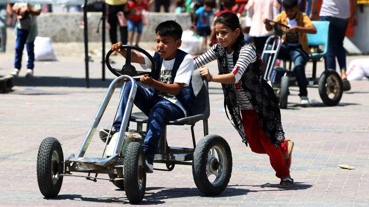 Iraqi kids enjoy at a fairground while celebrating Eid al-Fitr