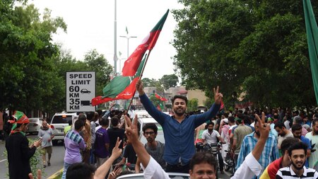 PTI supporters raise victory slogans as they march on a Lahore street
