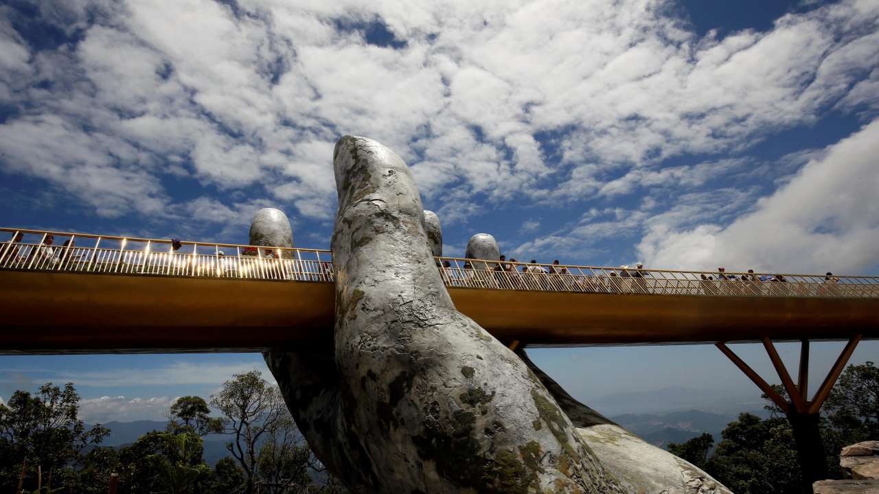 Tourists stand on Gold Bridge