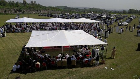 People visit an auction of government owned used cars at the premises of Prime Minister House in Islamabad