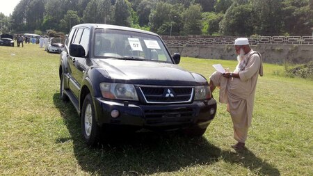 A man writes down the details of a government owned car on sale during an auction at PM House in Islamabad