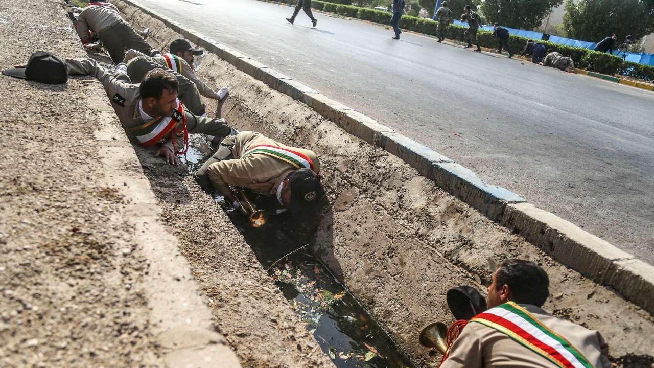 Iranian soldiers taking cover in a rain gutter