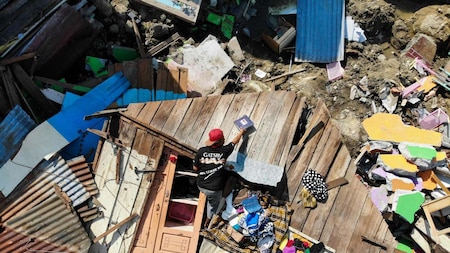 Man salvages useable items from the debris