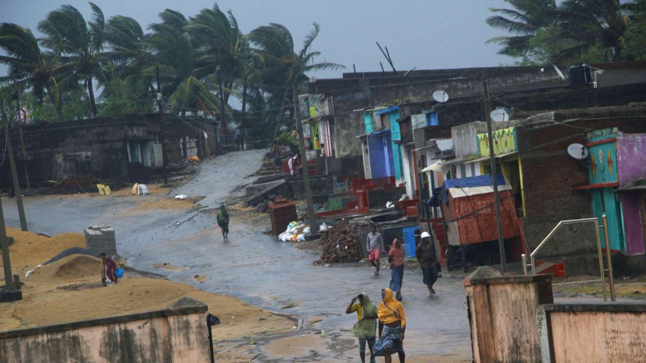 Locals walk near their houses as Cyclone Titli hits the coast, in Ganjam, Oct 11, 2018 (PTI)