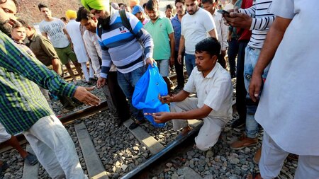 People collect body parts from railway track
