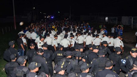 Guatemalan police officers talk to Honduran migrants
