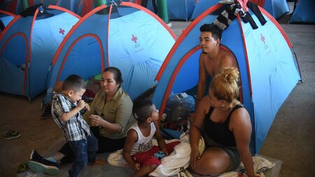 Honduran migrants rest next to tents at International Mesoamerican Fair's venue