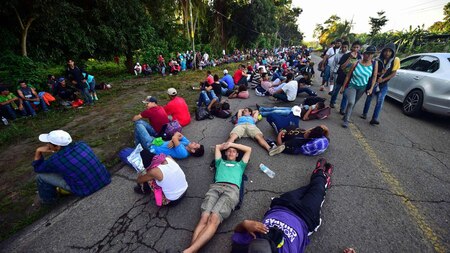 Migrants rest alongside the route