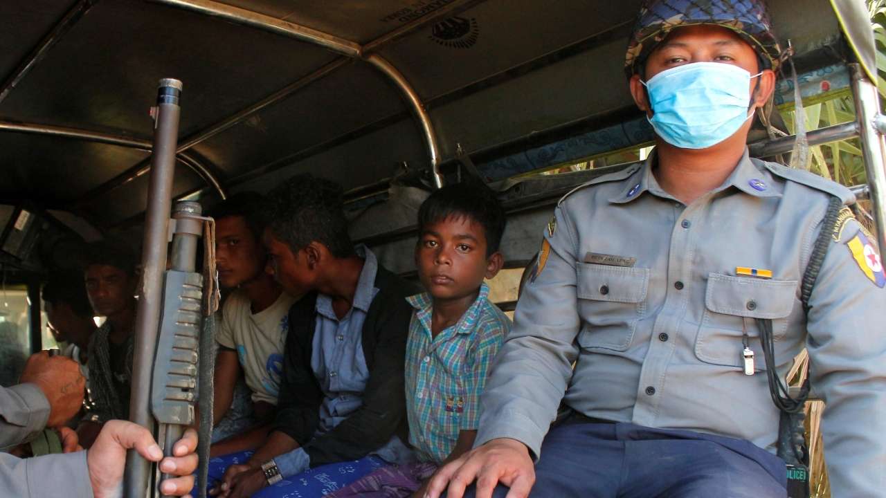 Rohingya Muslims detained by Myanmar immigration authorities are transferred into vehicles after arriving by boat at Thande vill