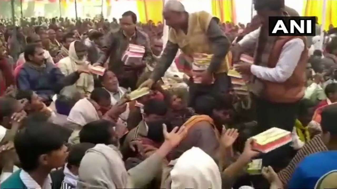 People distributing food packets with liquor