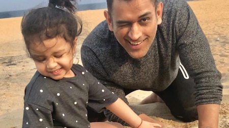 MS Dhoni and Ziva playing in the sand by the beach