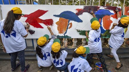 Students paint Indian soldiers on a canvas in Kolkata